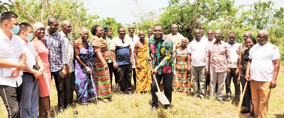 Ernest Victor Apau, the DCE, performing the sod cutting while some health workers, officials of the assembly, the contractors and residents look on  